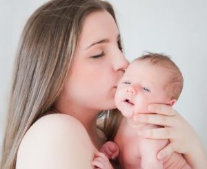 mamá besa a recién nacido