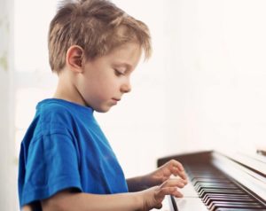 niño toca piano