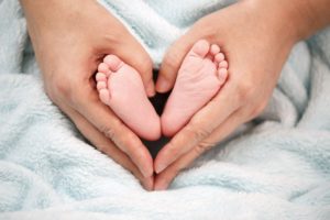 pies de bebe con manos de mama