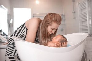 mamá baña a recién nacido