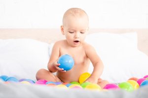 bebé juega con bolas de colores